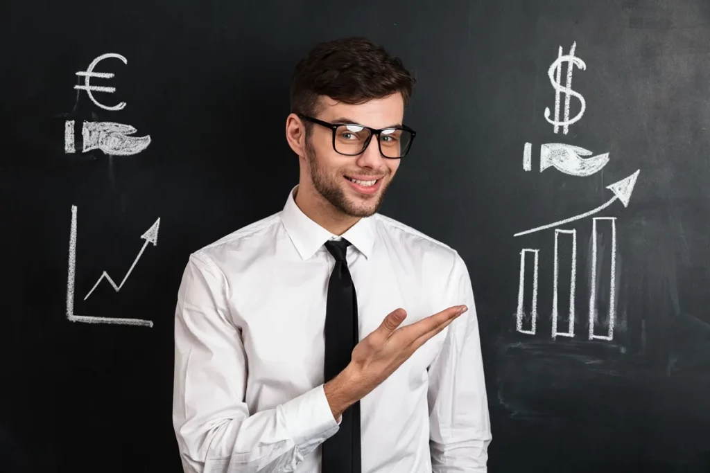 Homem sorridente de óculos e gravata apontando para ilustrações desenhadas em lousa com símbolos de crescimento financeiro, incluindo gráficos e ícones de moeda