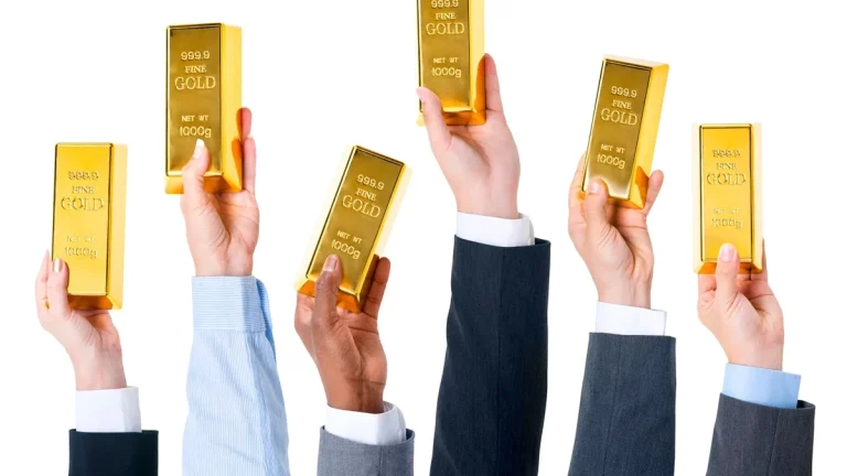 Várias mãos segurando barras de ouro brilhantes, representando investimento e riqueza.