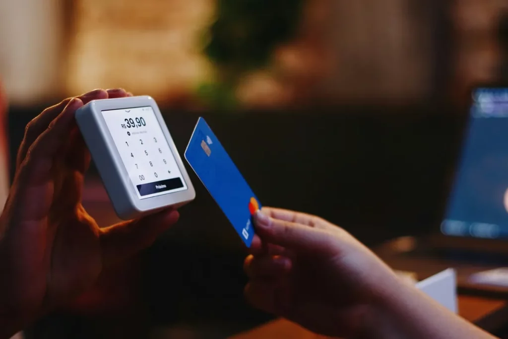 Pessoa realizando pagamento com cartão de crédito por aproximação em uma maquininha com valor de R$ 39,90 exibido na tela.