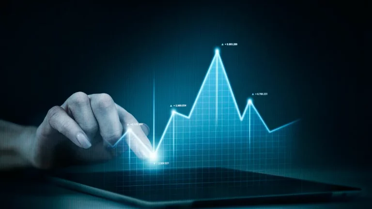 Pessoa tocando uma tela de tablet, interagindo com um gráfico de linha azul que mostra crescimento financeiro.