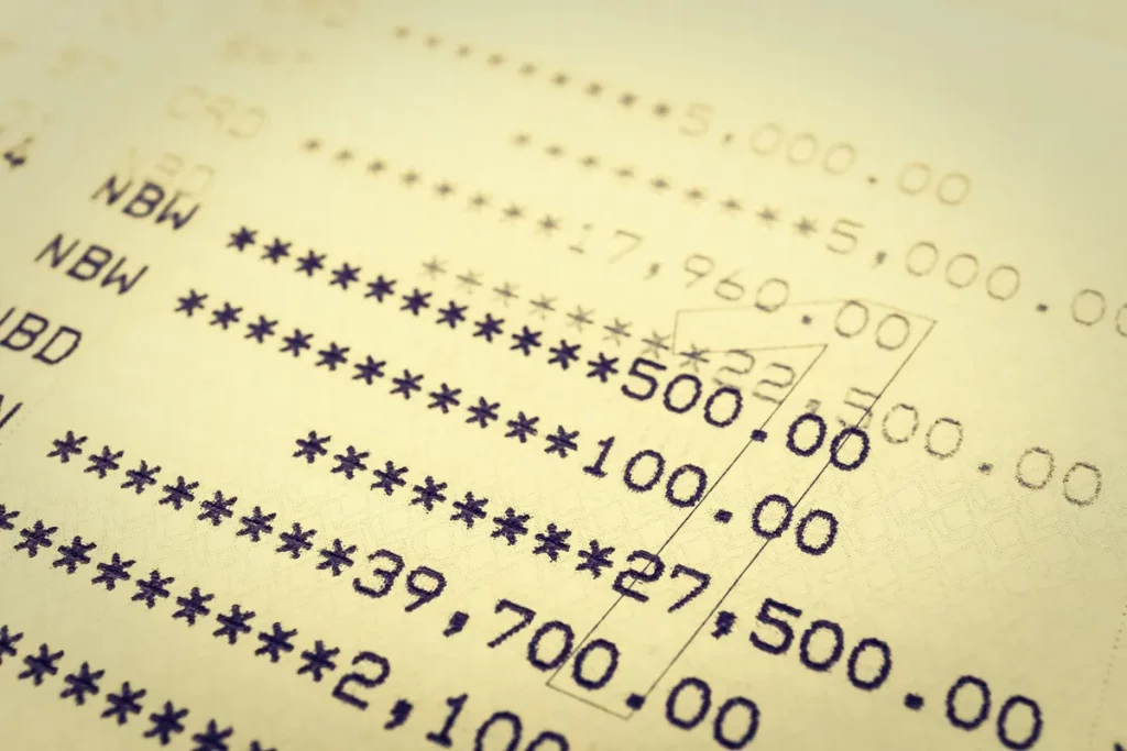 Extrato bancário impresso com números e códigos de transações, destacando valores e movimentações financeiras em destaque.