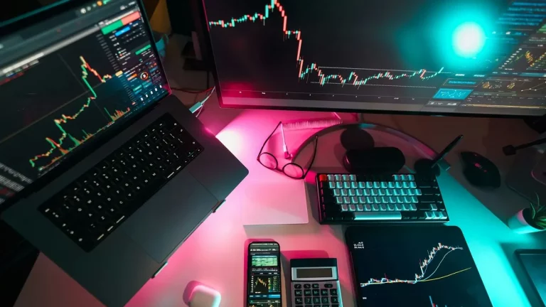 Estação de trabalho com múltiplas telas exibindo gráficos de ações e criptomoedas, ideal para análise técnica e avaliação do Índice de Sharpe em investimentos de alto desempenho.