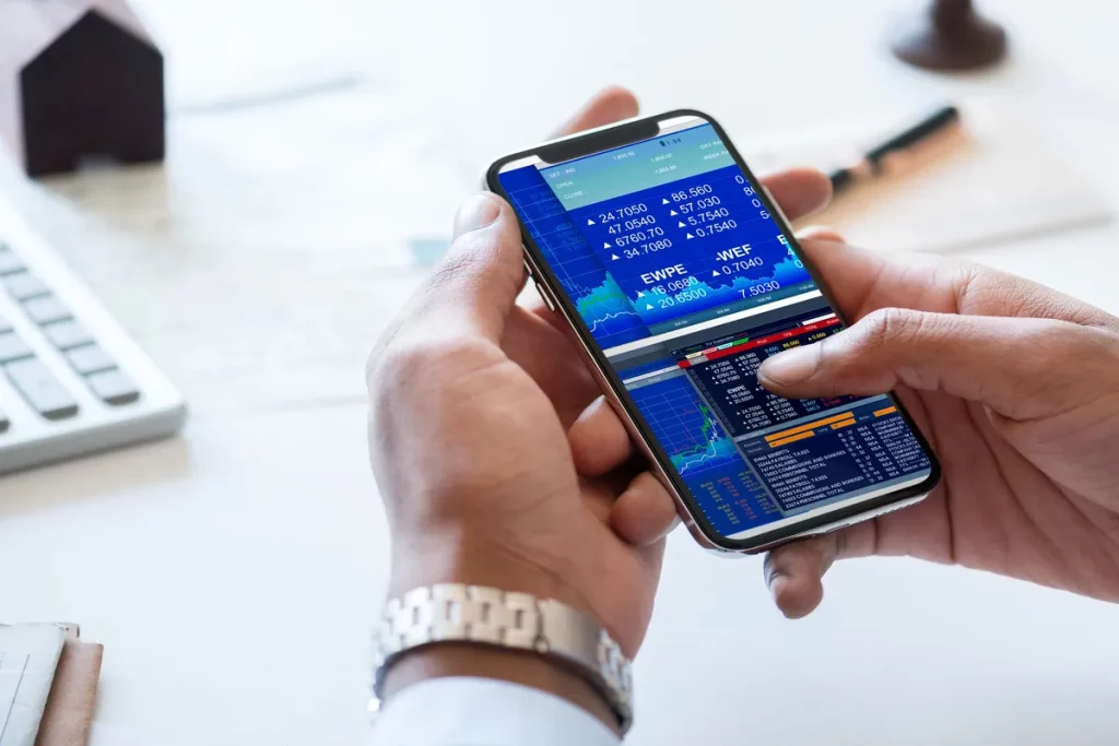 Pessoa analisando dados da bolsa de valores em aplicativo de smartphone.