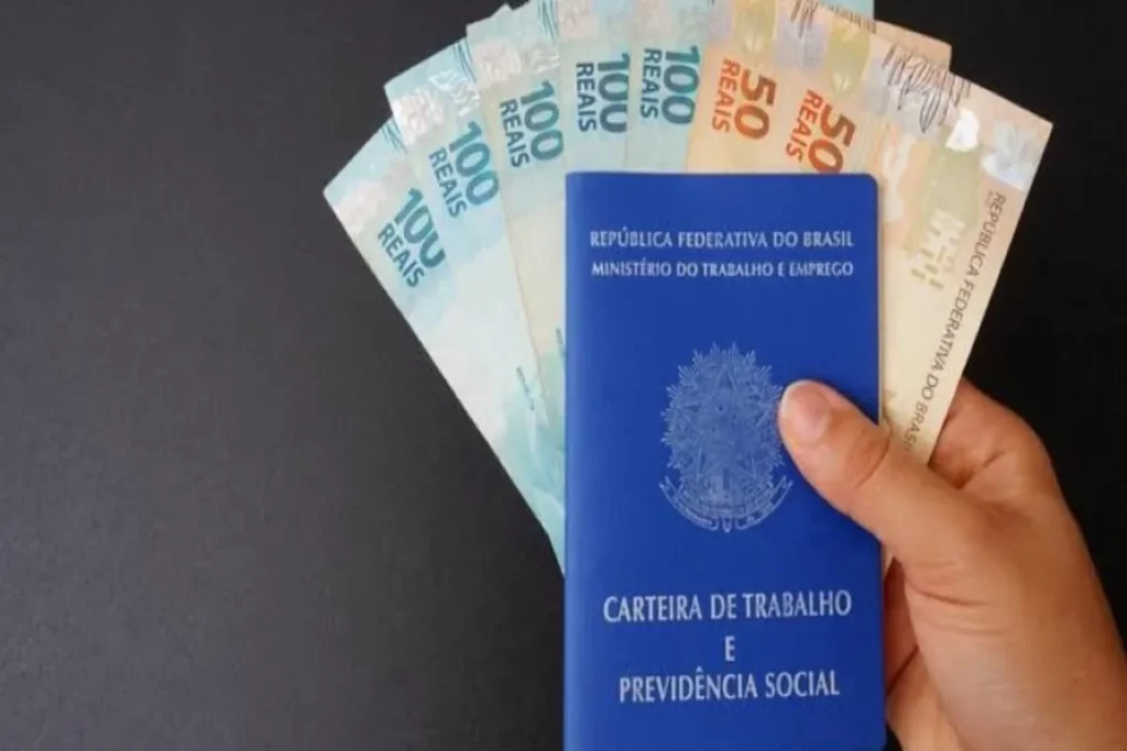 Seguro-desemprego, dinheiro em notas de real, carteira de trabalho e previdência social.