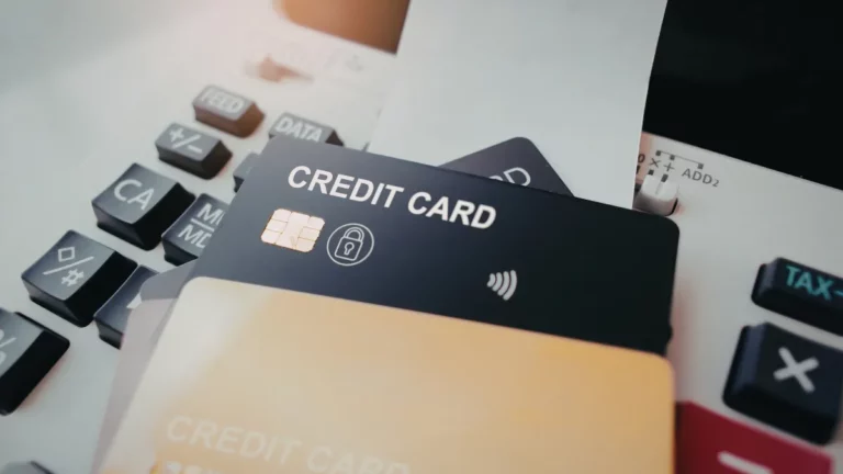 Cartão de crédito com a inscrição “credit card” ao lado de uma calculadora sobre a mesa.
